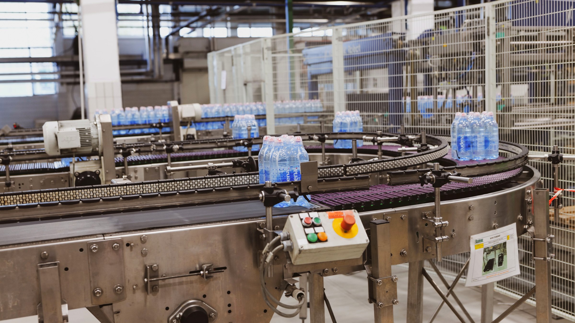 Packaging conveyor line with bottles moving through automated machinery
